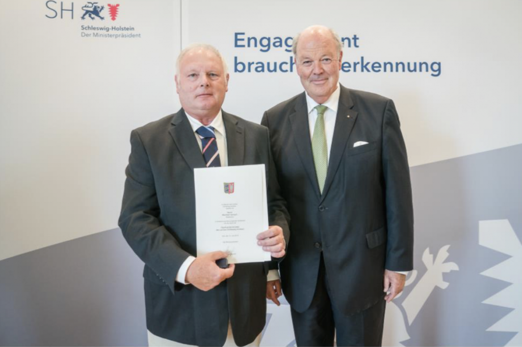 Manfred Gerlach mit der Urkunde für die Sportverdienstnadel